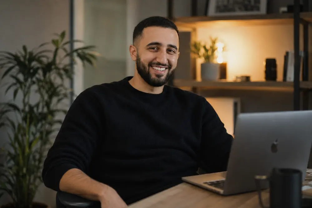 Portrait d'Ismael Hini, expert IA et Tech Lead, souriant devant son ordinateur